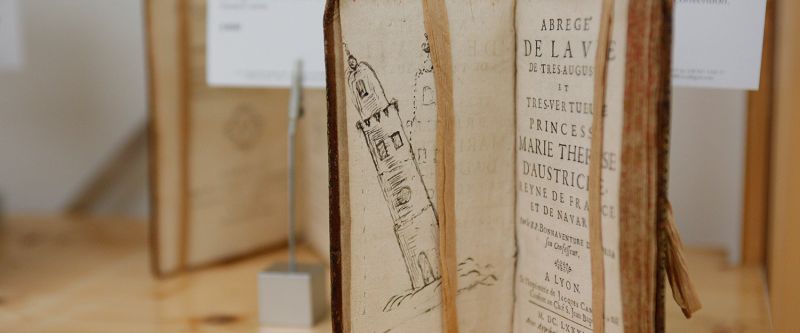 Old book with leaning tower in display case Old book with leaning tower in display case