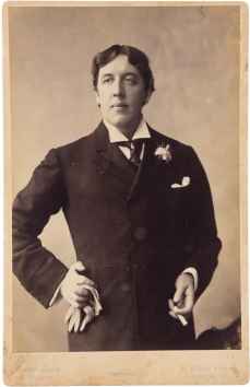 Oscar Wilde holding gloves and a cigarette.